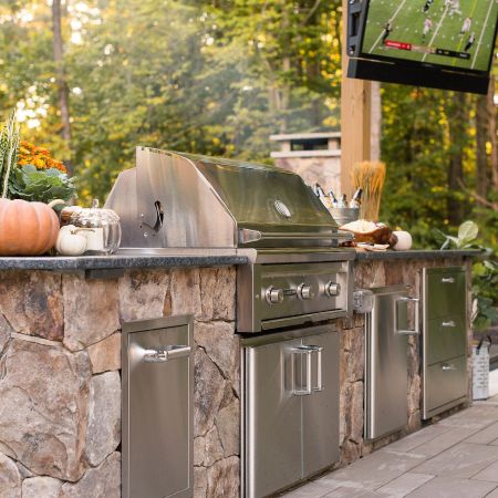 A stainless steel grill is installed into the outdoor kitchen countertop