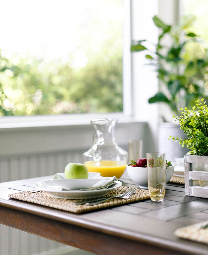 Screened-in porch table decorated for breakfast