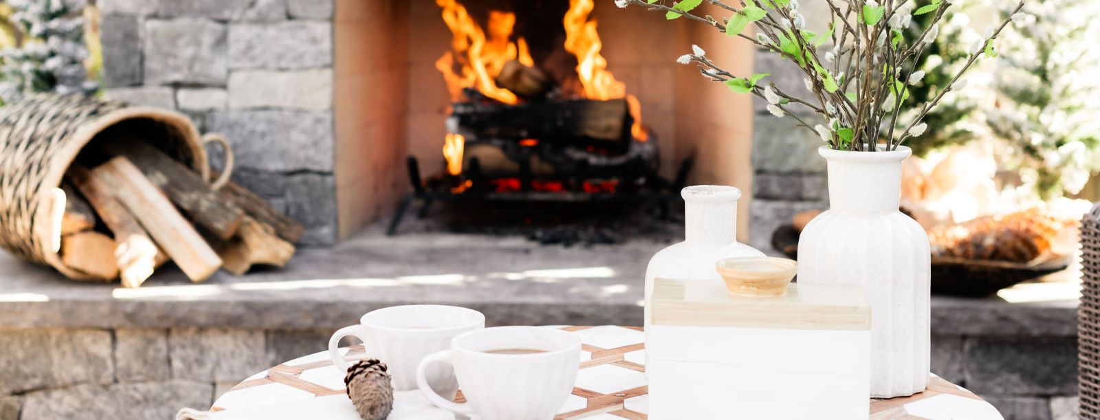 Cup of coffee or hot chocolate in front of an outdoor fireplace