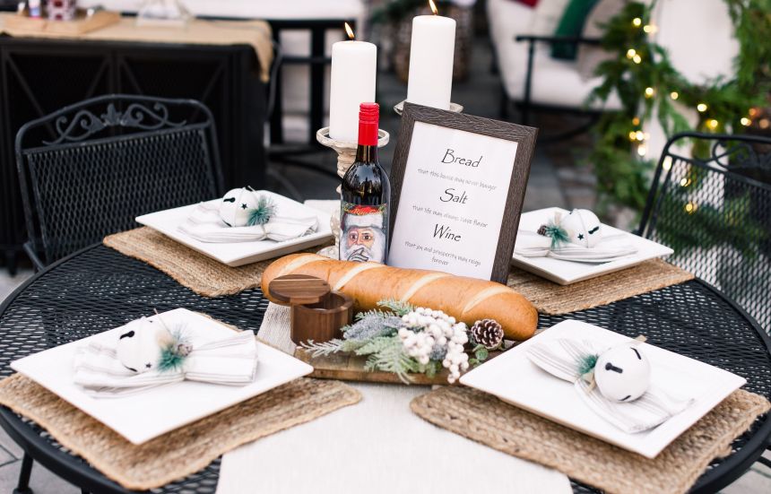 A metal wire outdoor table is set with bread wine and salt