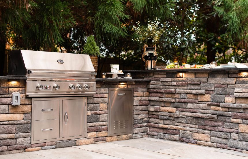 Outdoor Kitchen with premium grill, trash can and bar top seating