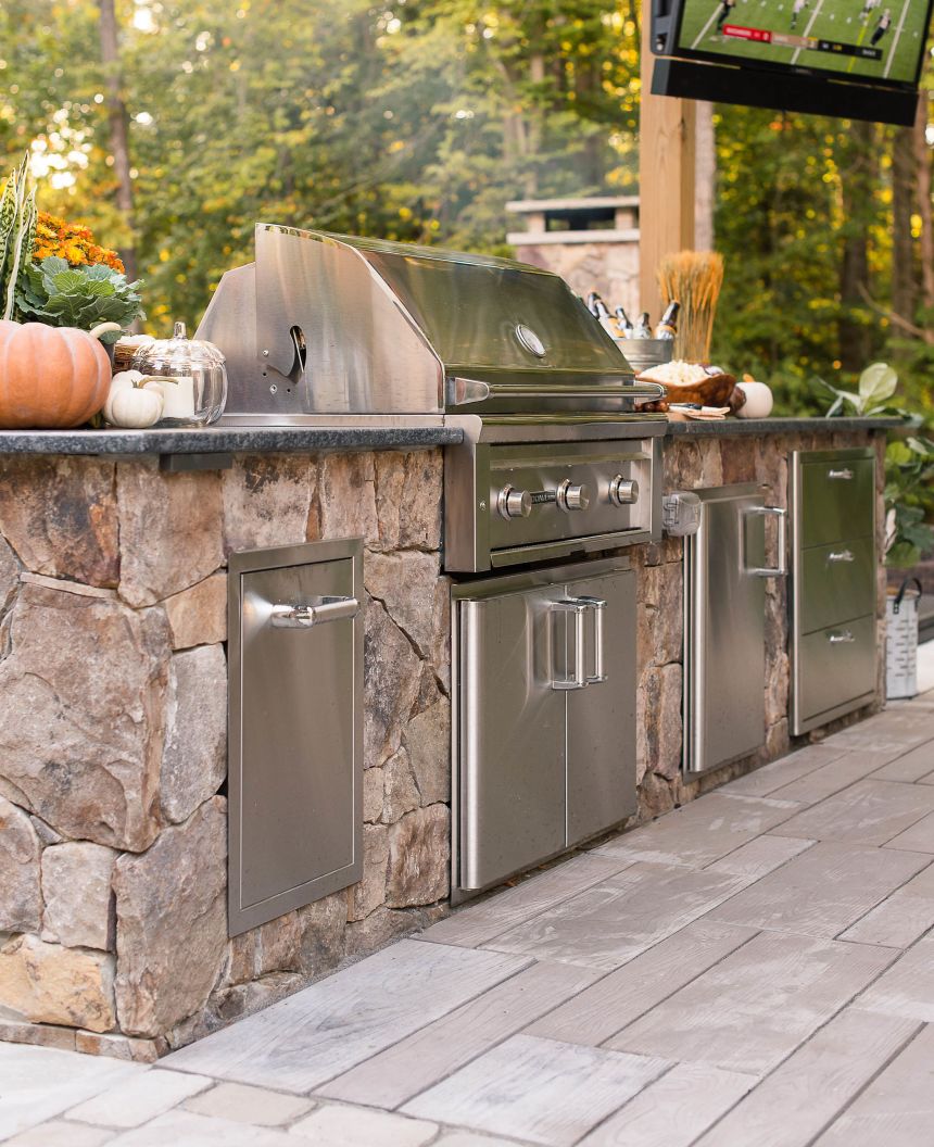 Outdoor kitchen with grill and outdoor television