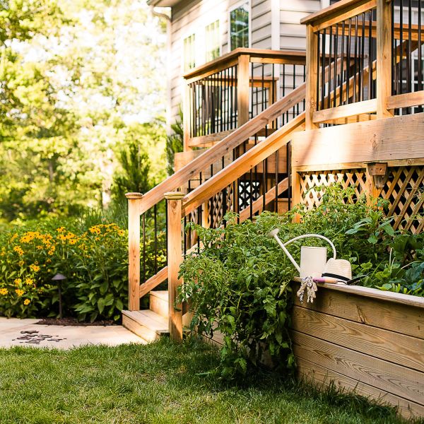 2-tiered Backyard wooden deck leads into herb garden