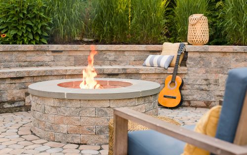 Wood burning fire pit on a paver patio and two chairs