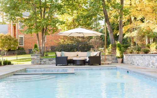 Gunite swimming pool with bluestone pool decking and stone wall