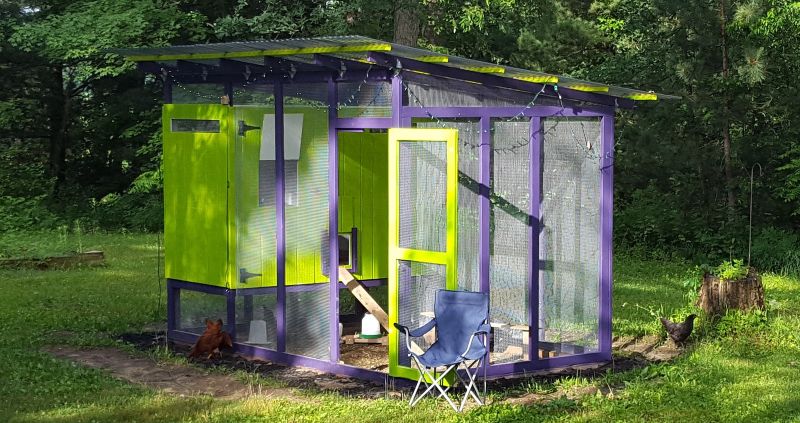 A ridiculous looking green and purple chicken coop