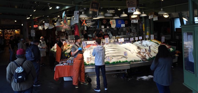 the famous fish mongers of pike place market in seattle standing around and talking to people