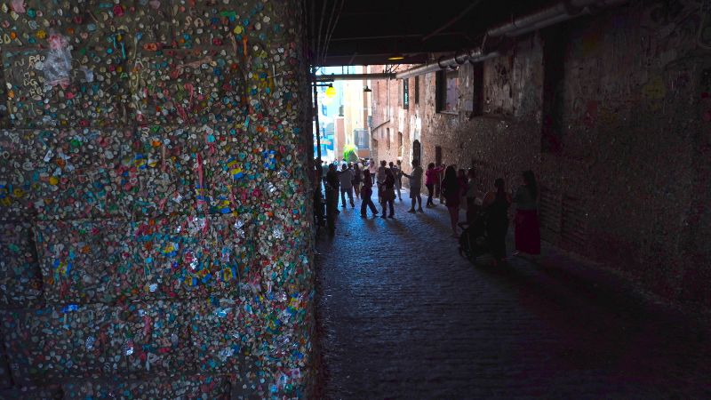 walls in an alley covered in thousands of pieces of chewing gum