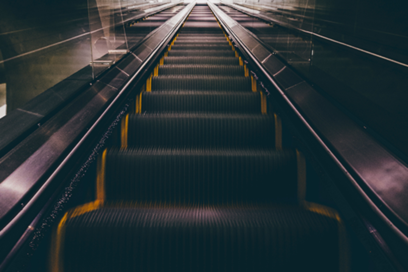 Image of an escalator looking down.