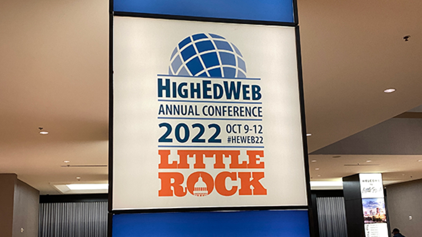 A sign promoting HighEdWeb 2022 in Little Rock.