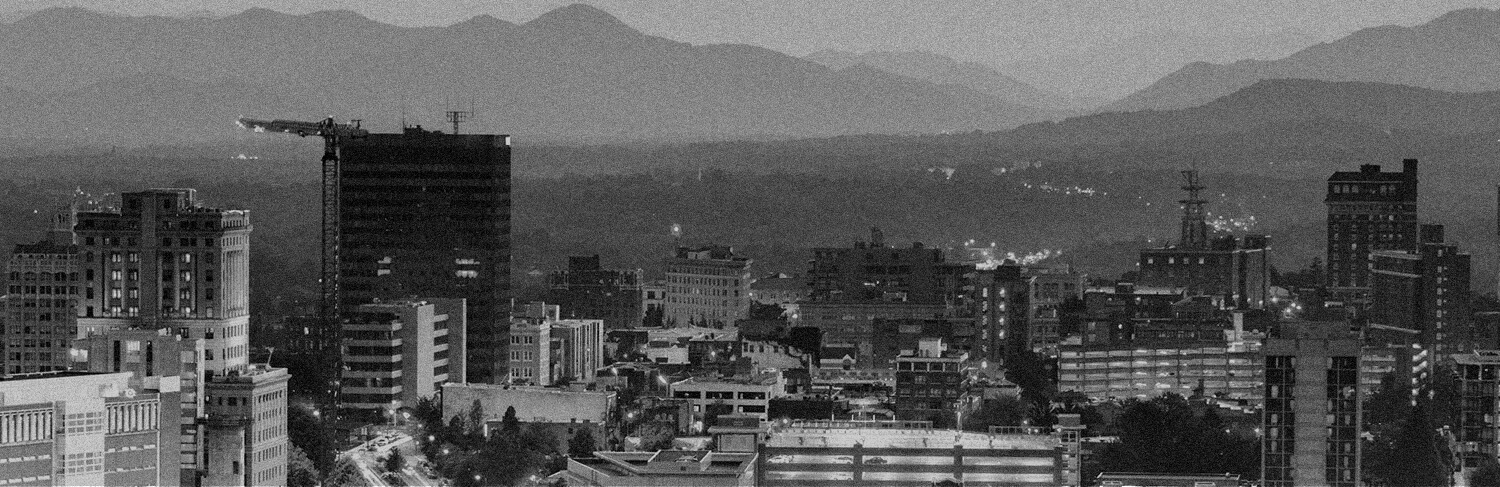 black and white panorama of buildings iand mountains in Asheville, NC