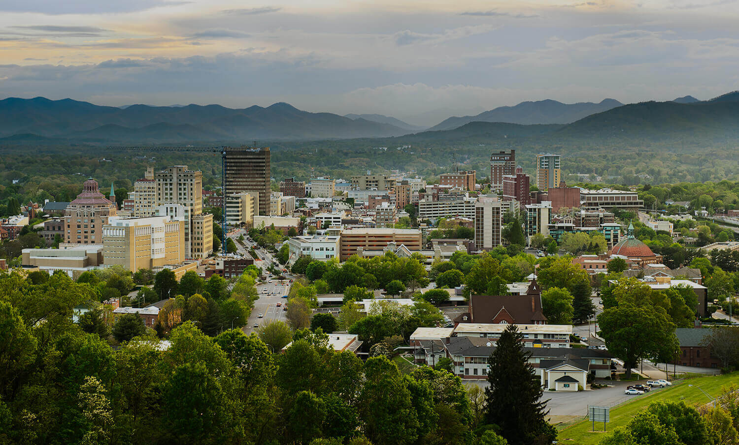 black and white panorama of buildings iand mountains in Asheville, NC