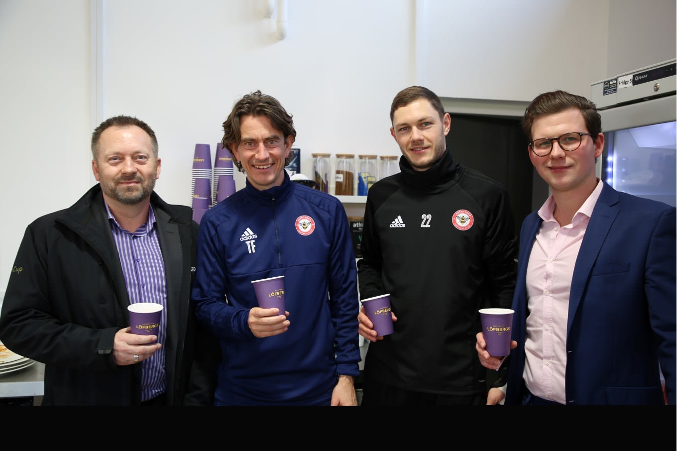Löfbergs and Brentford FC raise a cup as Löfbergs becomes official club supplier