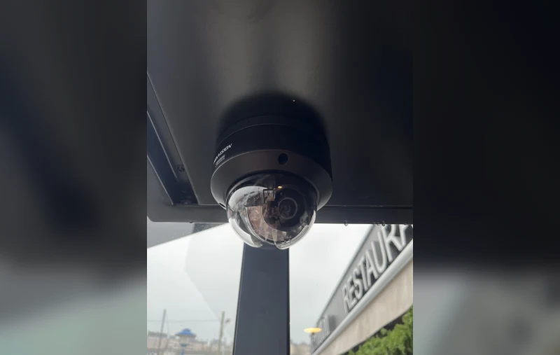 Caméra dôme Hikvision fixée sous l'auvent d'un commerce