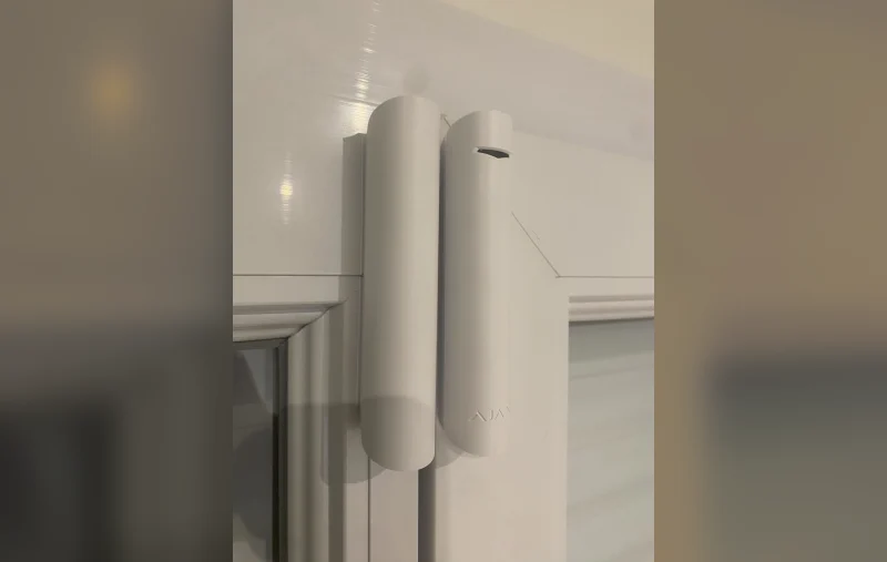 Contact d'ouverture fixé sur le dormant d'une fenêtre en PVC