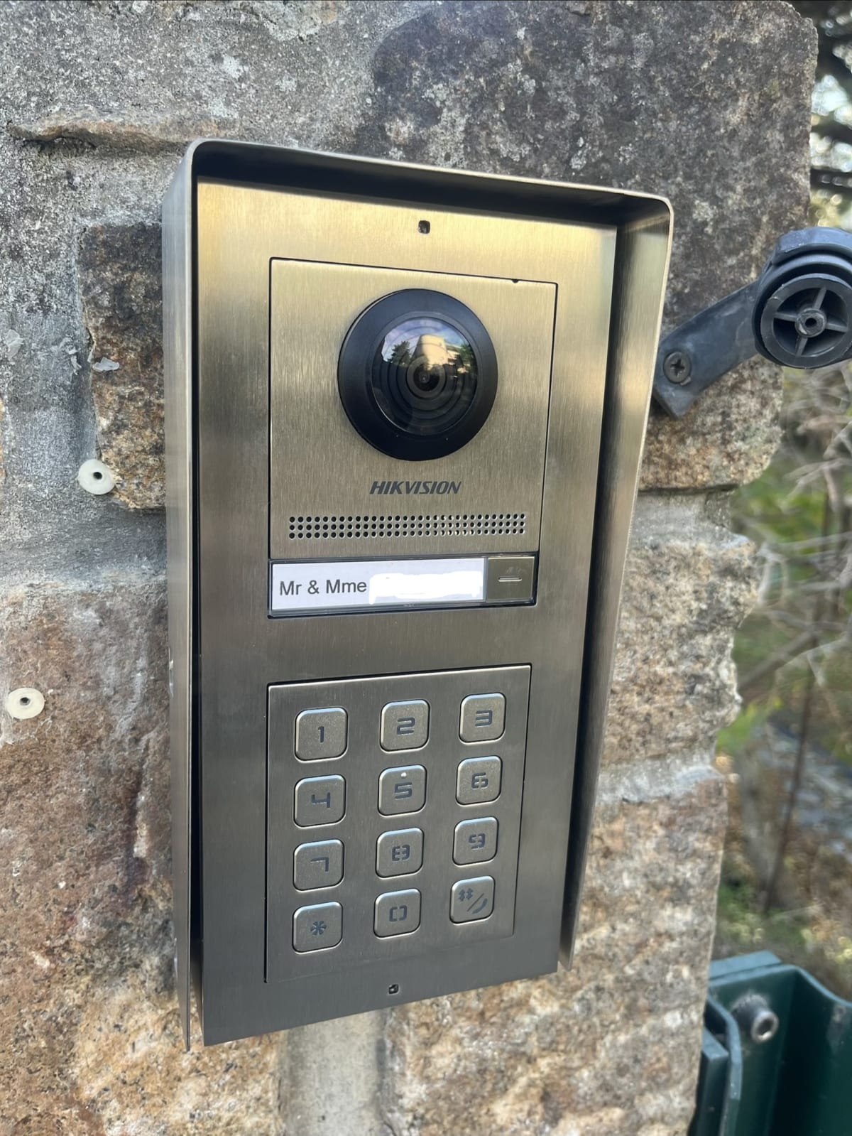 Platine de rue Hikvision en inox sur le pilier : caméra, bouton d'appel et clavier à code