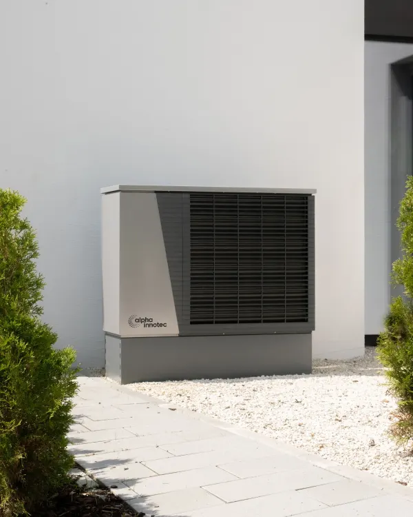 Unité extérieure de pompe à chaleur air-eau au pied d'une façade