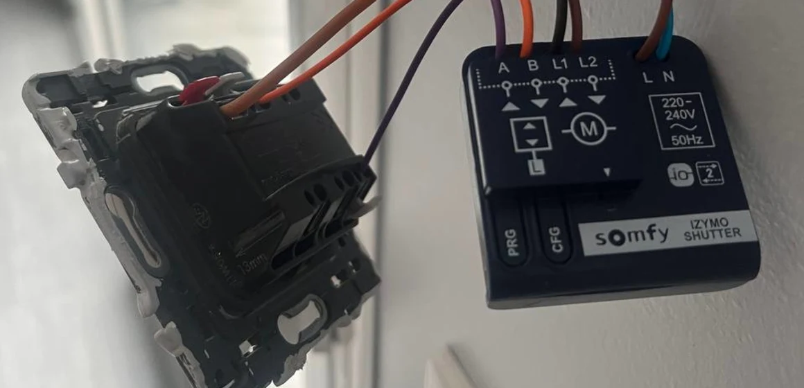 Micromodule Somfy raccordé derrière un mécanisme d'interrupteur, bornes à levier