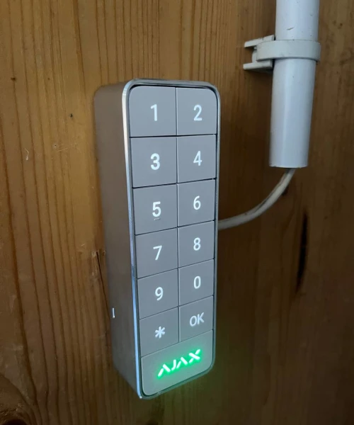 Clavier Ajax posé sur un mur en lambris, voyant vert allumé