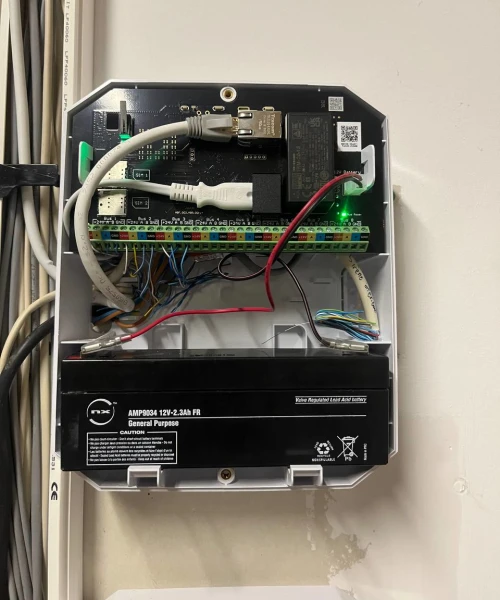 Centrale d'alarme ouverte au mur, carte électronique et batterie de secours dans le boîtier