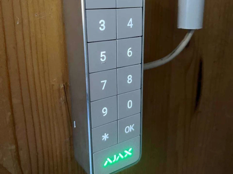 Clavier filaire Ajax à touches éclairées, fixé sur un bardage en bois