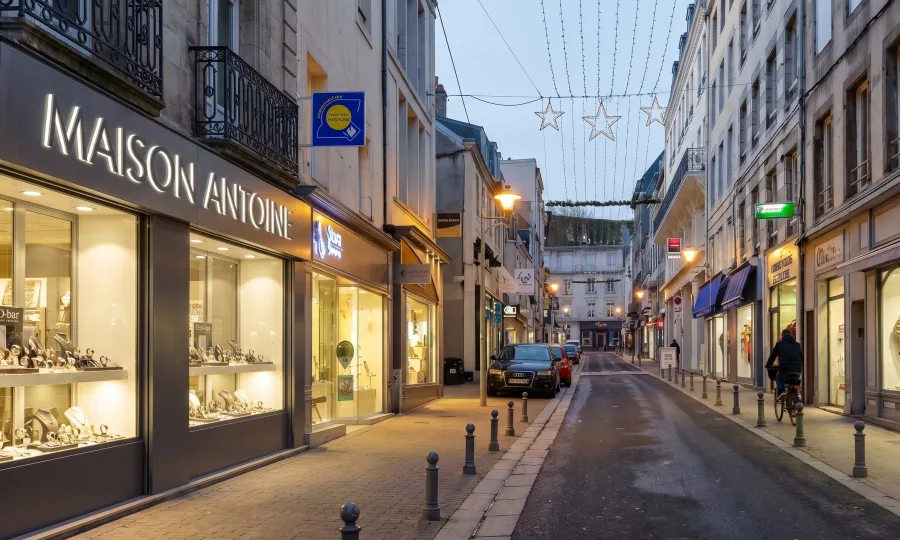 Rue commerçante, vitrine de bijouterie éclairée en soirée