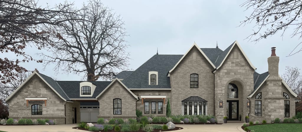 Grand brick and stone traditional home with a circular driveway