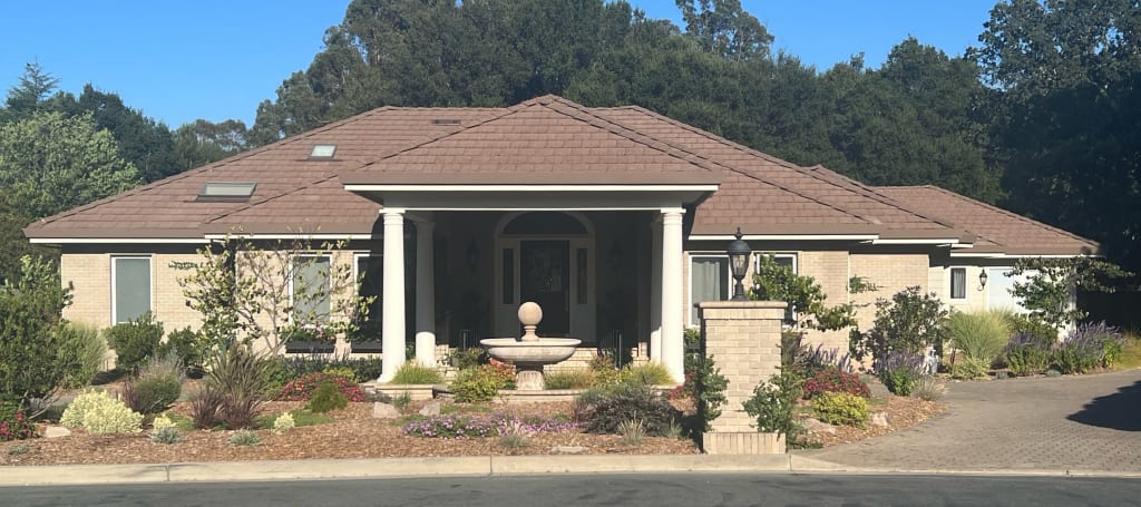 Single-story brick home with fountain.