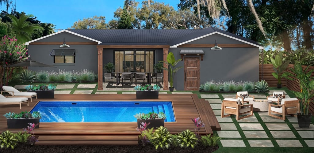 back of a home with a pool surrounded by wood decking