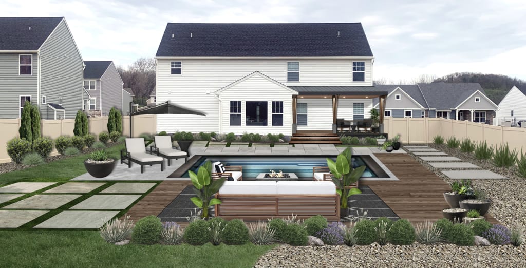 backyard pool surrounded by stone, pavers, wood decking, and patterned flagstone
