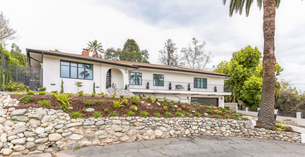 White house with black windows in California completed front façade, from an angle
