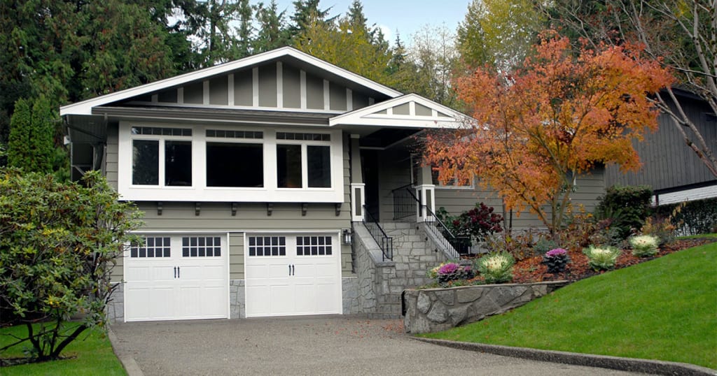 large gray home with white garage doors and trim