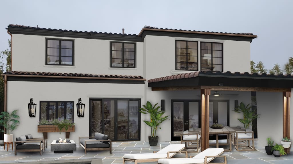 backyard view of a spanish style home with 2 stories and multiple slider doors leading out to patio furniture