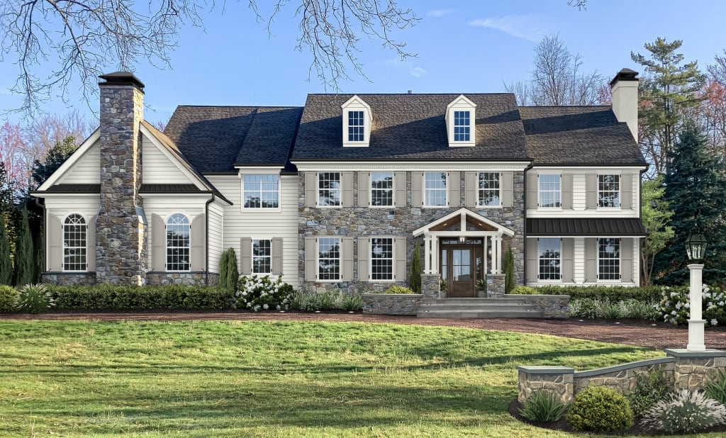 traditional house with white siding and natural stone