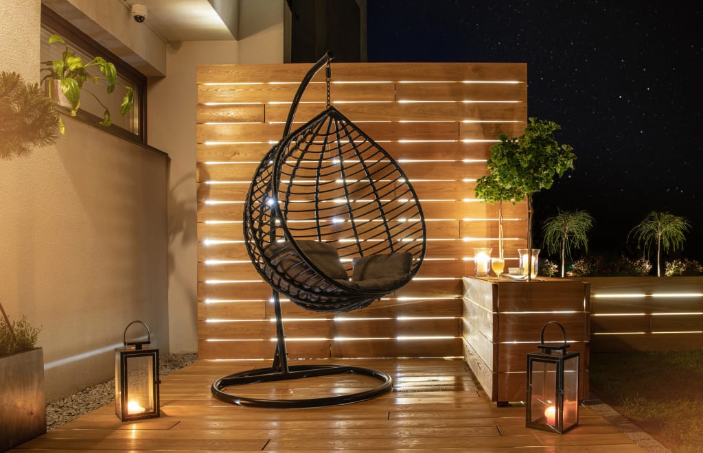 A porch seating area lit by lanterns and candles at night