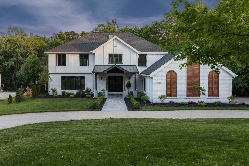 Modern white two-story farmhouse with black and wood accents