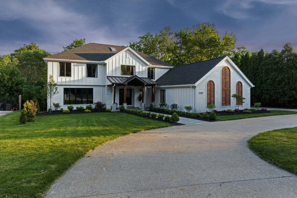 Modern white two-story farmhouse with black and wood accents