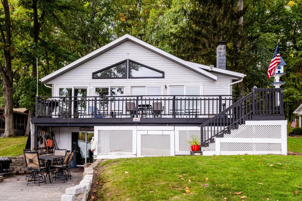A dated white lake house with black accents