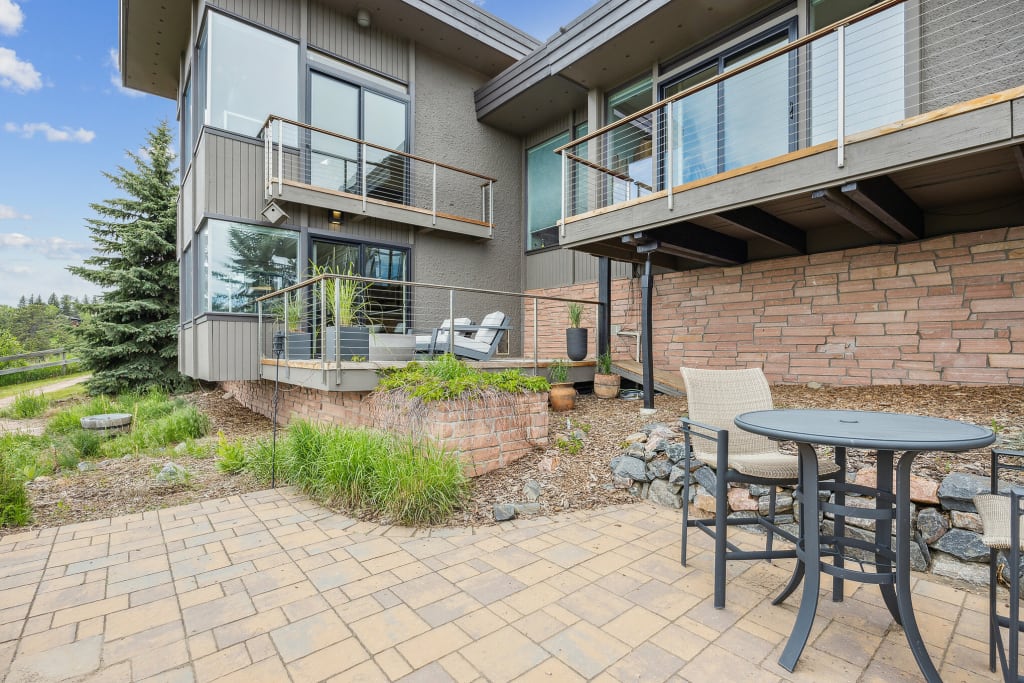 An actual after photo of the back of a Colorado home with a small deck and outdoor seating area