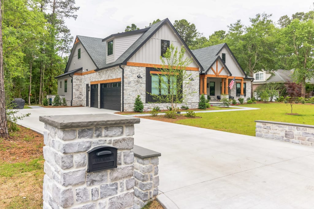 Grey stone veneer siding new build home actual after, angled front view