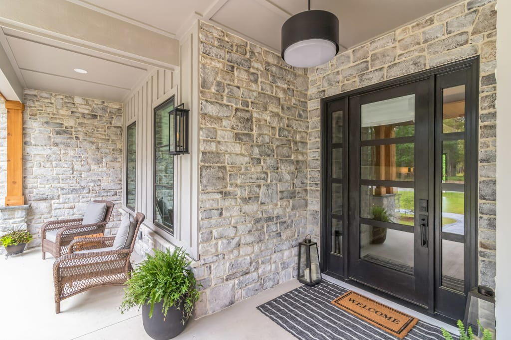 Grey stone veneer siding new build home actual after front entry detail
