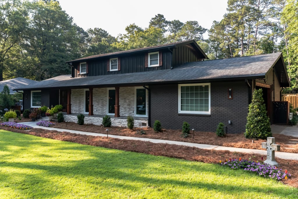 An actual after photo of a home with black siding and painted brick