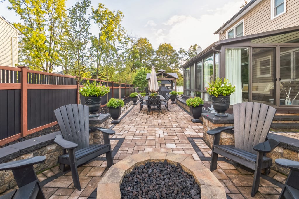 A photo of a backyard with fire pit and dining area