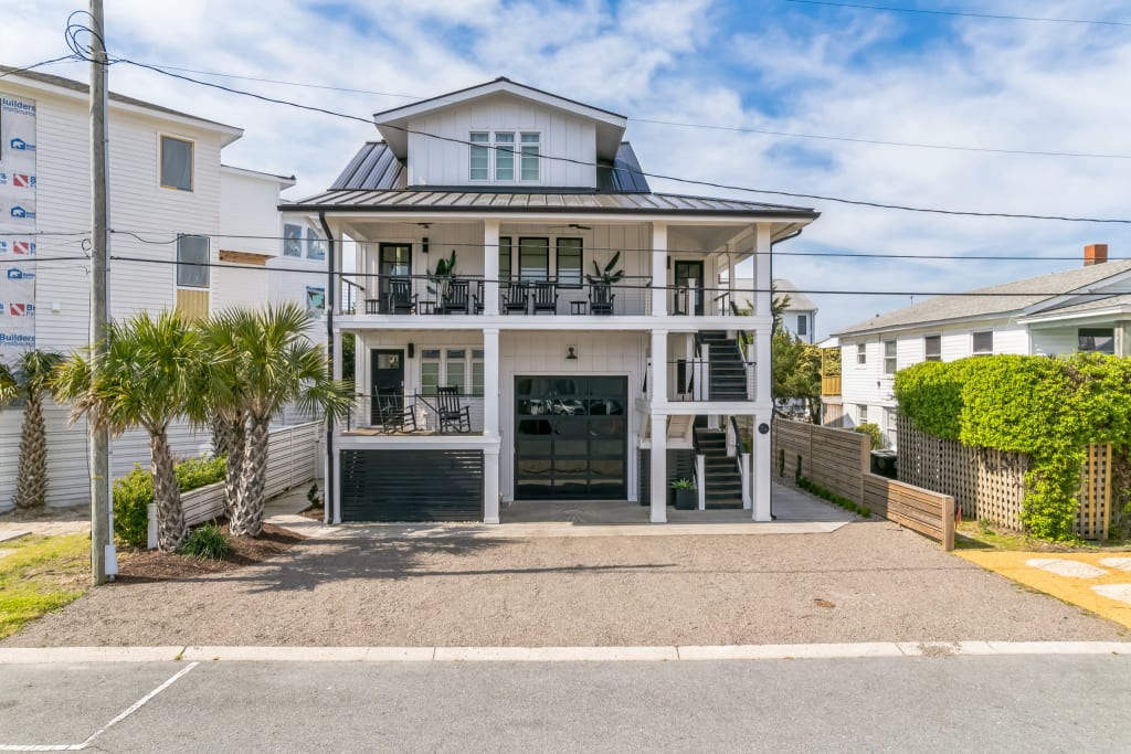Home exterior with white siding, black accents, and a black roof.