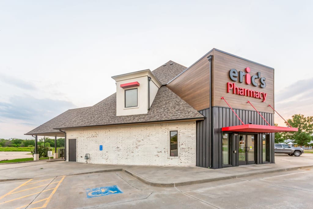 Commercial pharmacy exterior with wood and metal cladding and a bold color palette.