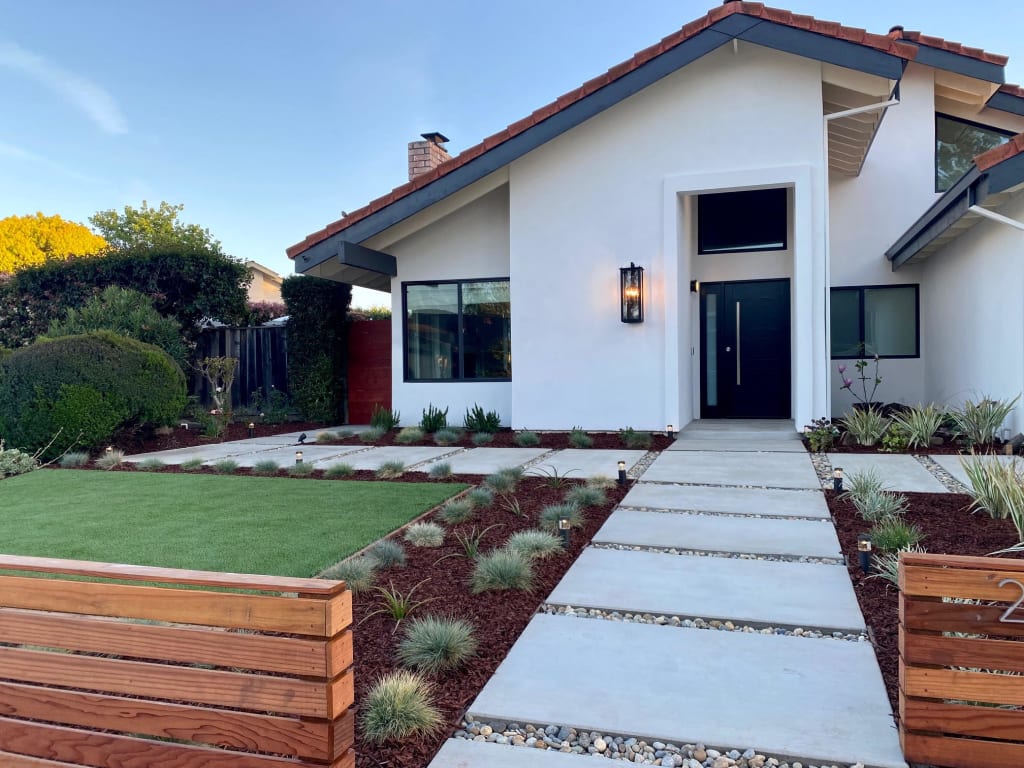 actual after photo of a modern white stucco house with landscaped yard