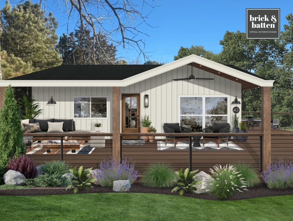 A small home with board and batten siding, a wood front door, white windows, and a front porch lounge area.