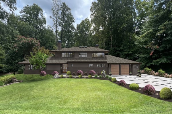A set back home with an earthy exterior design and landscape lighting ideas