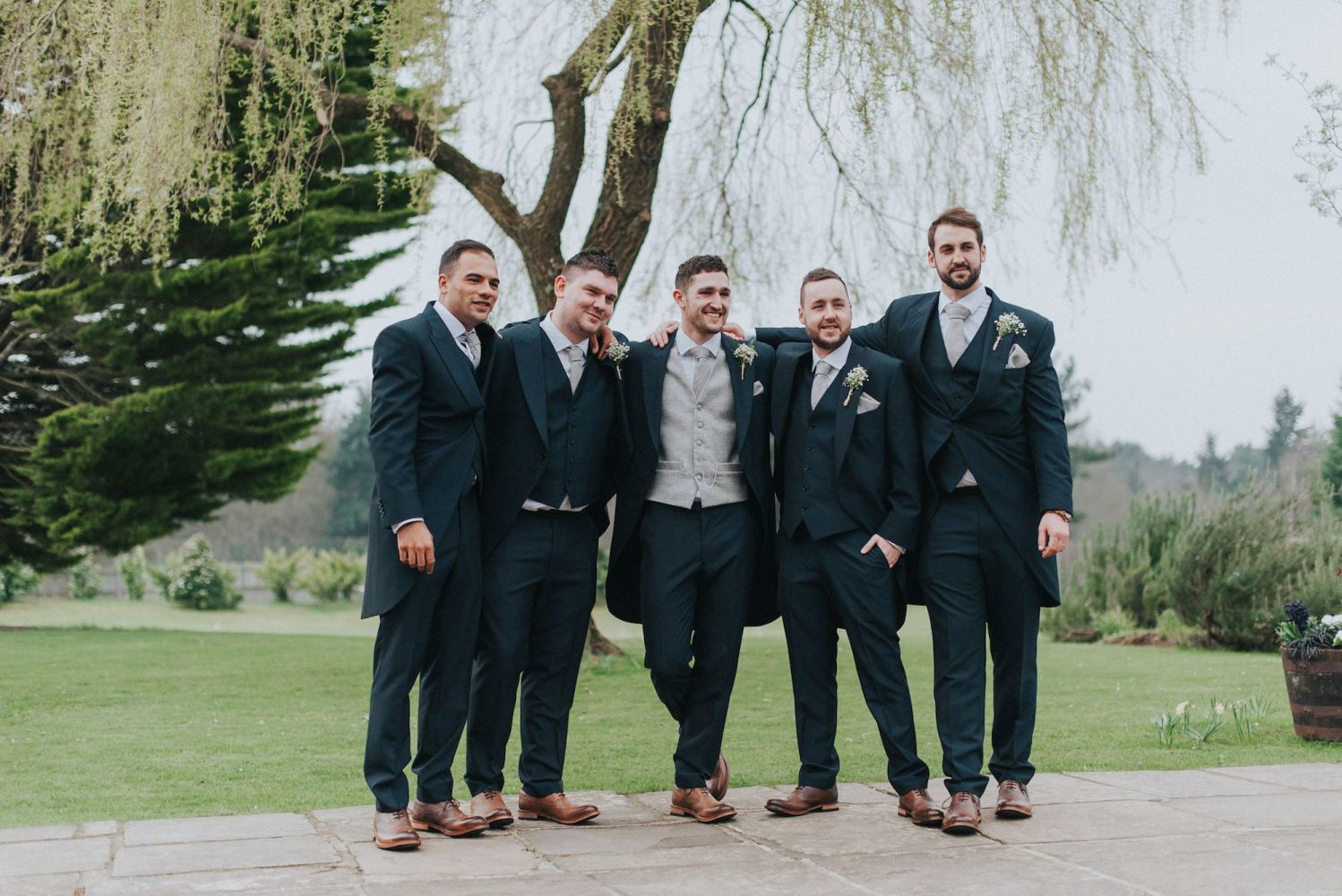 Adam and his best man standing outside the wedding venue in their wedding suits