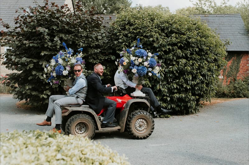 groomsmen carrying flowers on a truck